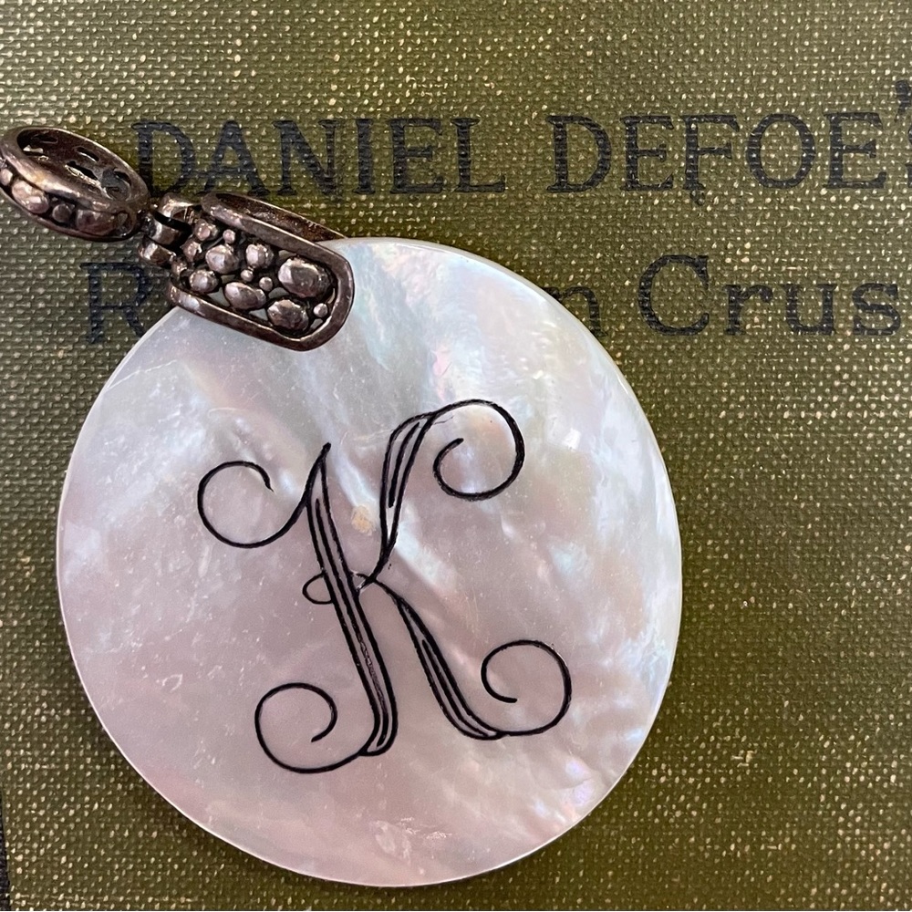 Mother of pearl pendant with K engraved.